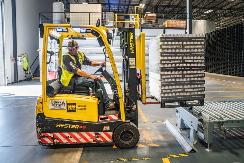 person using forklift in warehouse